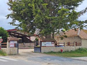 a building with a tree in front of it at Chambres d'hôtes Provins in Poigny