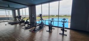 a gym with several treadmills and a swimming pool at Cozystayz NuNa in Sitiawan