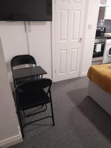 a room with a chair and a bed and a kitchen at Gosford Park Studio 2 - Coventry in Coventry +6 photos