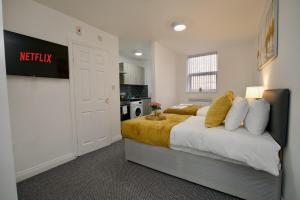 a bedroom with a king sized bed and a kitchen at Gosford Park Studio 2 - Coventry in Coventry