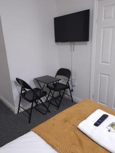a room with a table and chairs and a flat screen tv at Gosford Park Studio 2 - Coventry in Coventry