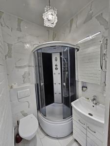 a bathroom with a shower and a toilet and a sink at Bella Donna Hotel in Chişinău
