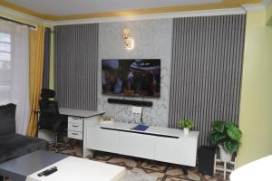 ナイロビにあるMWANGO HOMES - Elegant, Cozy, Homely 1-bedroom at Mirema Driveのリビングルーム(白いキャビネット、壁掛けテレビ付)