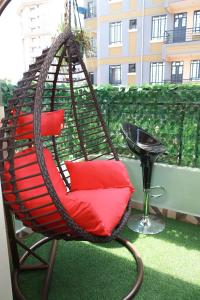 ナイロビにあるMWANGO HOMES - Elegant, Cozy, Homely 1-bedroom at Mirema Driveのバルコニー(スイングチェア、赤い枕付)