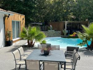 a patio with a table and chairs next to a pool at Little Paradise in Belin-Beliet