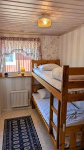 Un dormitorio con dos literas y una ventana. en Stor älg, en Dalskog