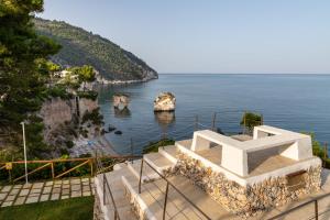 a view of the ocean from the steps of a building at AH Premium Baia dei Faraglioni in Mattinata