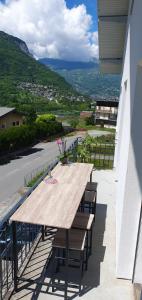 un tavolo in legno con sedie e un balcone con vista. di Appartement au cœur de la Vallée de la Maurienne a Saint-Julien-Mont-denis Altre 6 foto