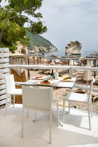 a table and chairs on a patio with a view of the ocean at AH Premium Baia dei Faraglioni in Mattinata