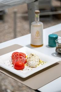 a plate of food and a bottle of wine on a table at AH Premium Baia dei Faraglioni in Mattinata