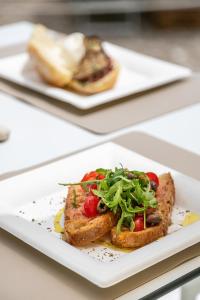 a plate of food with toast and vegetables on it at AH Premium Baia dei Faraglioni in Mattinata