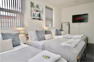 a room with three beds and a flat screen tv at Gosford Park Studio 4 - Coventry in Coventry +8 photos