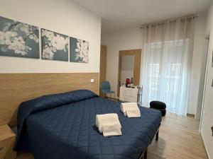 a bedroom with a blue bed with towels on it at B&B La Dimora in Gissi