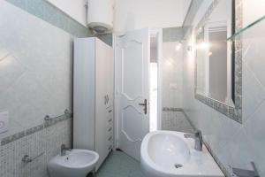 Un baño blanco con lavabo e inodoro. en Villetta Teresa - Salento Reservation, en Capilungo
