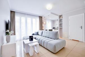 biały salon z kanapą i stołem w obiekcie Promenada by Baltic Home w Świnoujściu