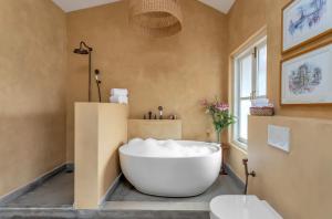 a bathroom with a large white tub in a room at La Pasado, Huge 4 BHK villa with Large Private Pool & Garden, in Assagao, Complimentary Breakfast, full time caretaker, Bathtub, ideal for large groups in Assagao