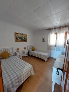 a room with two beds and two tables in it at Gran Vista - playa y piscina in Gran Alacant +44 photos