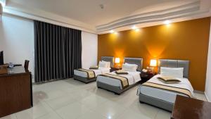 una camera d'albergo con due letti e una televisione di Tetra Tree Hotel 1 a Wadi Musa