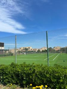 Una cancha de tenis con una valla en un campo en studio village naturiste, en Leucate