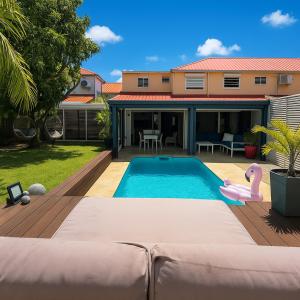 a swimming pool with a pink flamingo in a backyard at Villa Tropiraizet in Les Abymes