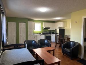 kuchnia z czarnymi skórzanymi krzesłami i stołem oraz kuchnia z blatem w obiekcie Lakeshore Suites w mieście North Bay