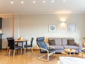 a living room with a couch and a table and chairs at Holiday Home Blu Hus in Freest