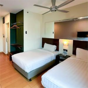 a bedroom with two beds and a ceiling fan at Tune Hotel – Kota Bharu City Centre in Kota Bharu