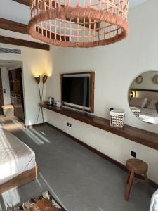 a bedroom with a bed and a tv and a mirror at Hacienda Bay Lagoon and Seaside Serviced Cabana - Le Sidi hotel in El Alamein