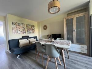 a dining room with a table and a blue couch at Apartamento da Fraga in Arzúa