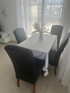 a white table with chairs and a plant on it at Appartement avec Vue sur Mer à Praia, Wi-Fi, Navette Aéroport in Praia