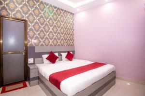 a bedroom with a large bed with red pillows at Hotel Ayodhya Palace - 400 Mtrs from HANUMAN GARHI in Ayodhya