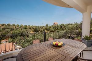 a bowl of fruit on a wooden table on a balcony at Zen Maisonette Retreat in Daratso