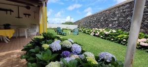 a garden with flowers and a stone wall at Mosteiros Sea House in Mosteiros