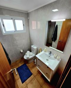 a bathroom with a sink and a toilet and a mirror at Mosteiros Sea House in Mosteiros