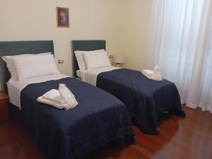 two beds in a room with blue sheets at Casa MAMMA in Lovere