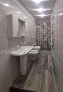 a white bathroom with a sink and a toilet at Giuius home Apartment in Camposano
