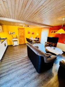 un soggiorno con divano e una cucina con pareti gialle di Sonnenblume - Sonne 2 rechts a Zingst