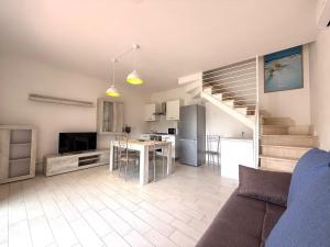 salon z kanapą, kuchnią i schodami w obiekcie Villetta Acacia K&G House w mieście Viddalba