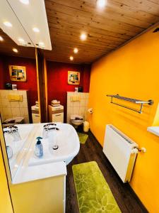 bagno con lavandino bianco e pareti gialle di Sonnenblume - Sonne 2 rechts a Zingst Altre 10 foto