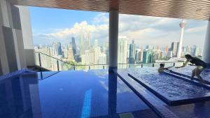 a woman and a child playing in a swimming pool on top of a building at Colony Service Suites Kuala Lumpur in Kuala Lumpur