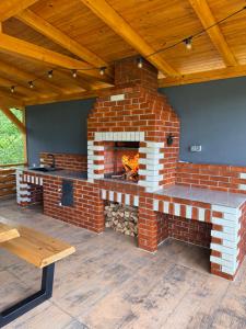 a brick fireplace in a patio with a wooden ceiling at Julien House in Prisaca Dornei