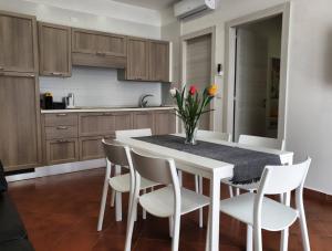 a kitchen with a white table and white chairs at Dafne Home in Pompei
