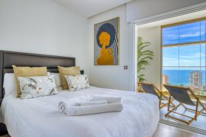 a bedroom with a large white bed with a large window at Intempo by Holuxe - 036 - 3rd floor in Benidorm +40 photos