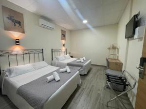 a room with two beds and a chair in it at Hostal Balmes Centro in Barcelona