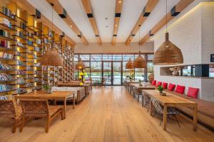 a restaurant with tables and chairs and bookshelves at Manli Hotel Shanghai Pudong Airport Branch -Provide free shuttle buses to Pudong Airport and Disneyland in Shanghai
