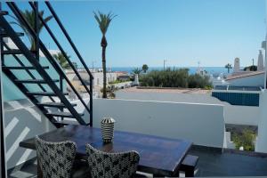 a table and chairs on a balcony with a view of the ocean at La Casa de las Musas, pequeño chalet junto al mar in Mojácar