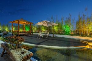 a patio with tables and umbrellas next to a pool at Manli Hotel Shanghai Pudong Airport Branch -Provide free shuttle buses to Pudong Airport and Disneyland in Shanghai