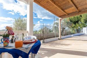 ein Tisch mit einem Krug Orangensaft auf einer Terrasse in der Unterkunft Villetta Tiziana - Salento Reservation in Marina di Mancaversa
