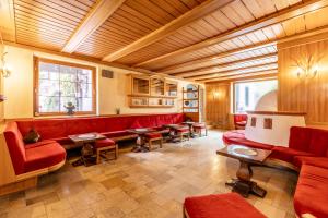 een woonkamer met rode banken en tafels bij Pop-up Hostel - Loisach in Lermoos +5 foto's