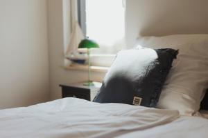 un letto con un cuscino bianco e nero di NEU "Rügen Resørt Sagard" großzügige, gemütliche Doppelhaushälfte "Lasse" mit Terrasse a Sagard